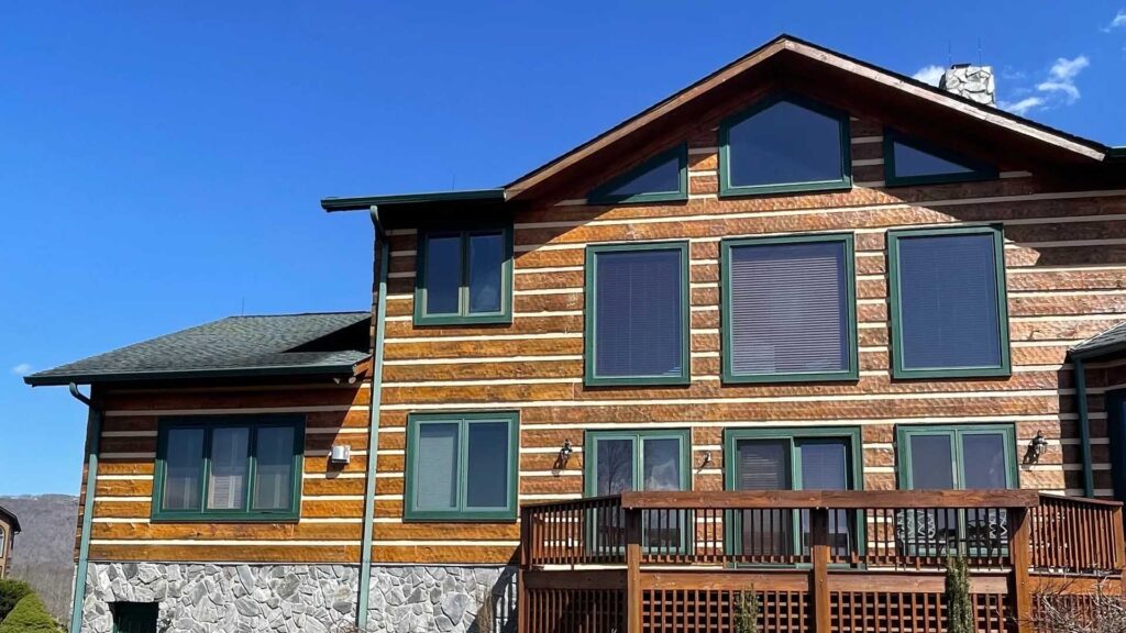 a beautiful two story log cabin with a large number of windows